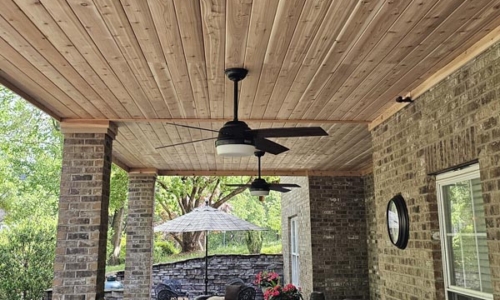 Photo of a comfortable, lodge-like space underneath a large wooden deck construction